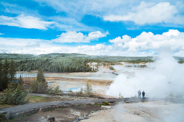 Folyam jön ki, mielőtt hatalmas mennyiségű forró patak tört ki fák és hóhegy háttér Yellowstone Nemzeti Park - Fotó, kép
