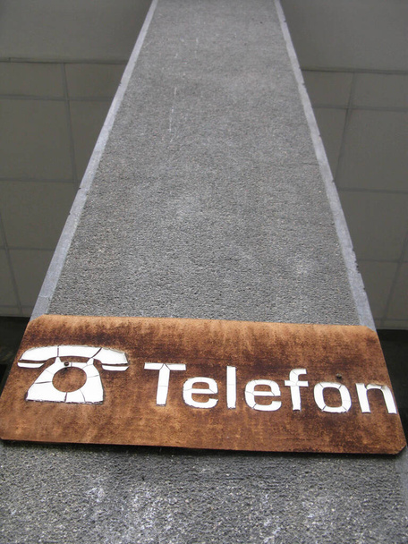 Kahverengi zemin üzerinde alıcısı olan beyaz bir sabit telefon sembolü - Fotoğraf, Görsel