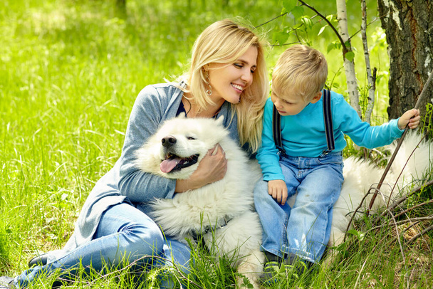 outdoor portrait mother, son and dog. child and mom walking samoyed laika. - Foto, Bild