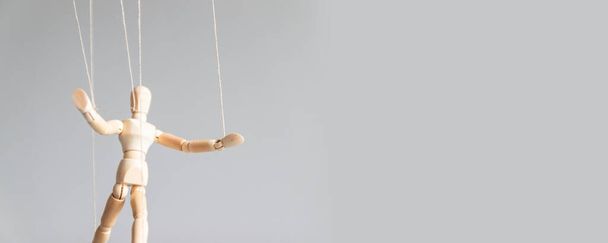 Figura de árbol humano con hilos suspendidos en el aire con espacio de copia sobre un fondo gris. Manipulación, concepto de adicción
. - Foto, imagen