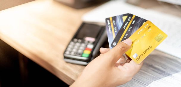 Ręczne trzymanie karty kredytowej i karty kredytowej maszyny, Karta kredytowa przygotować dla klienta i przedsiębiorcy przy użyciu do zakupów online, e-commerce, biznesu i bankowości internetowej z laptopem. - Zdjęcie, obraz