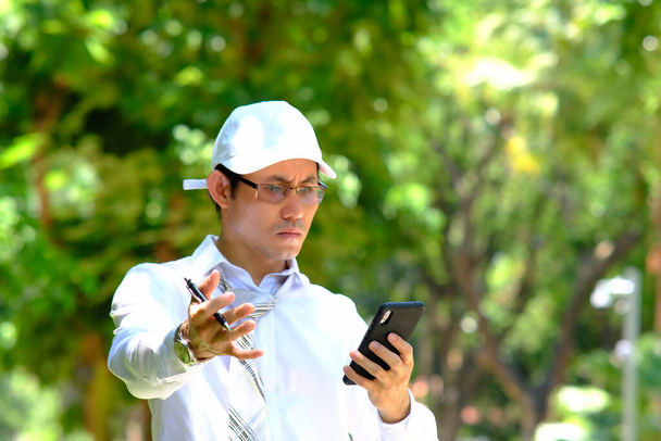 businessman using smartphone and reading a business newspaper - Φωτογραφία, εικόνα