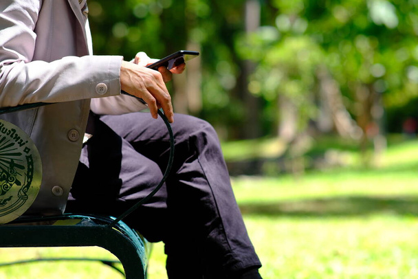 επιχειρηματίας που χρησιμοποιεί smartphone και διαβάζει επιχειρηματική εφημερίδα - Φωτογραφία, εικόνα