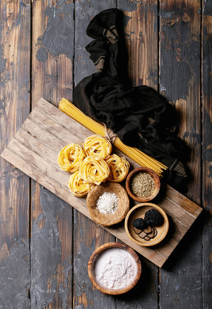 Home made egg pasta served with truffles, truffle infused oil and saltover wooden background. New concept of raw foods. Top view, flat lay. Copy space - Photo, Image