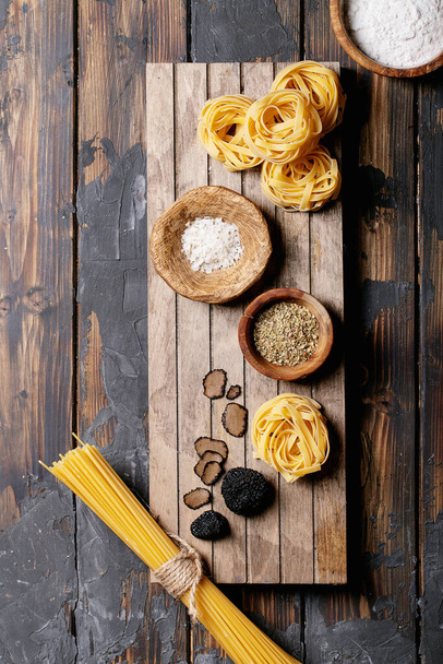 Home made egg pasta served with truffles, truffle infused oil and saltover wooden background. New concept of raw foods. Top view, flat lay. Copy space - Fotoğraf, Görsel