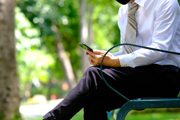businessman using smartphone and reading a business newspaper - Photo, Image