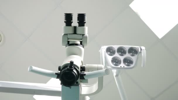 Microscopio dental en gabinete dental blanco, ángulo bajo. La dentista enciende la lámpara. Instrumento Moderno en Clínica Dental. 4 k vídeo
 - Metraje, vídeo