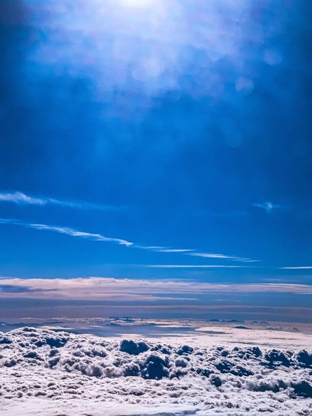 Высокоугольный вертикальный снимок захватывающих дух облаков в небе, захваченных сверху - Фото, изображение