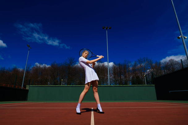 Szczęśliwa piękna seksowna dziewczyna grająca w tenisa na korcie. Sport i rekreacja, wypoczynek. - Zdjęcie, obraz