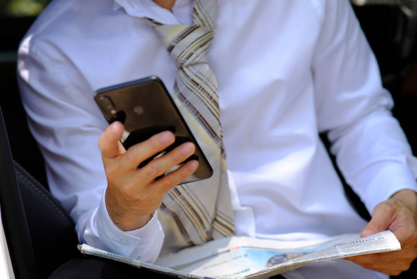 бізнесмен використовує смартфон і читає новини бізнесу
 - Фото, зображення