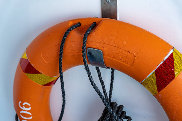 Boia salva-vidas laranja a bordo de um navio
 - Foto, Imagem
