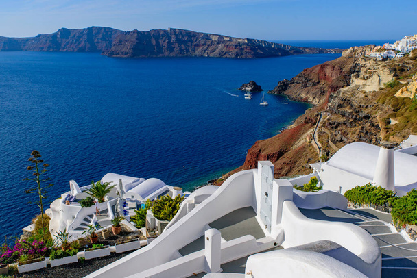 Tradycyjne białe budynki z widokiem na Morze Egejskie w Oia, wyspa Santorini, Grecja - Zdjęcie, obraz