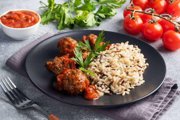 Beef meatballs and brown rice on a plate. Ready made portioned dish meat with garnish - Photo, image
