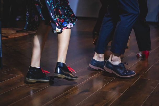 Dancing shoes of young couple dance retro jazz swing dances on a ballroom club wooden floor, close up view of shoes, female and male, dance lessons - Photo, image