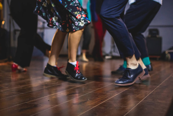 Dancing shoes of young couple dance retro jazz swing dances on a ballroom club wooden floor, close up view of shoes, female and male, dance lessons - Foto, Bild