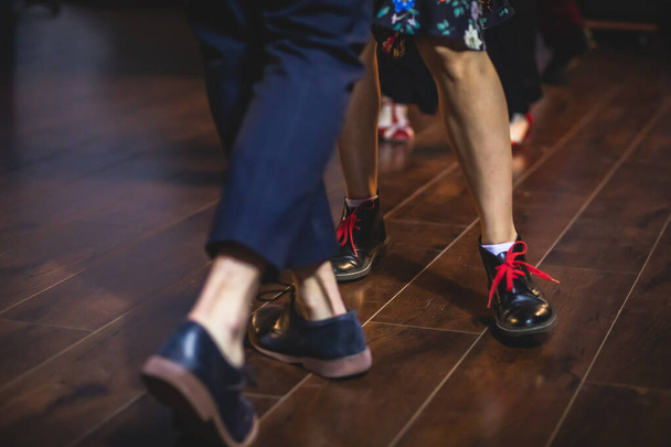 Dancing shoes of young couple dance retro jazz swing dances on a ballroom club wooden floor, close up view of shoes, female and male, dance lessons - Fotografie, Obrázek