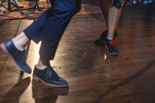 Dancing shoes of young couple dance retro jazz swing dances on a ballroom club wooden floor, close up view of shoes, female and male, dance lessons - 写真・画像