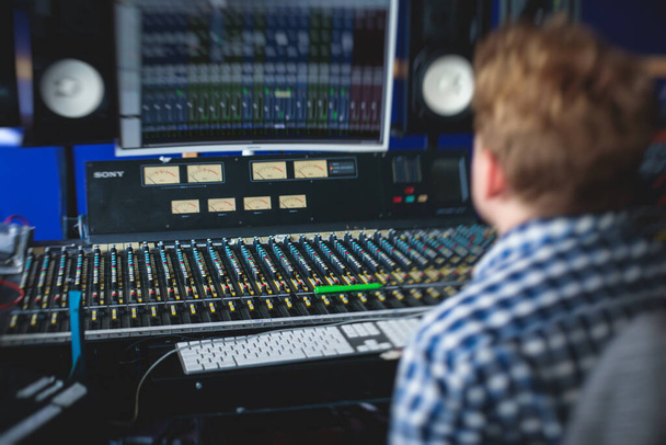 Sound editor engineer working at studio with mixing panel, mixing music and sound, stage sound mixer, boutique recording studio, working during concert performance recording, broadcasting studio - Φωτογραφία, εικόνα