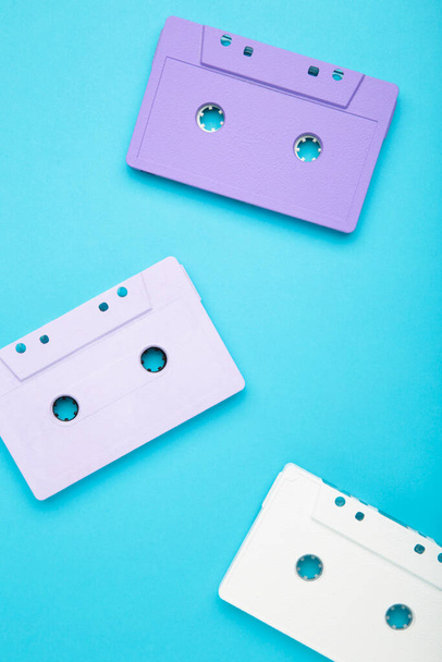 Old colorful cassettes on a blue background. Music day, top view - Fotó, kép