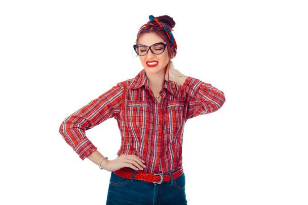 Tired woman having pan in neck. Closeup portrait of a beautiful girl in red checkered shirt and jeans with retro bow on head isolated on pure white background. Mixed race, hispanic, caucasian model - Photo, Image