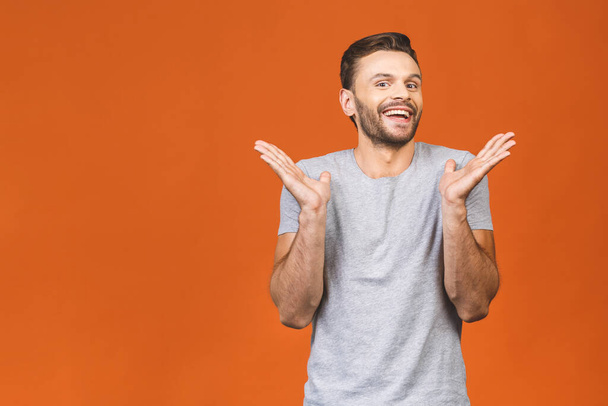 Portrait of young man with shocked surprised facial expression isolated against orange background.  - Fotoğraf, Görsel