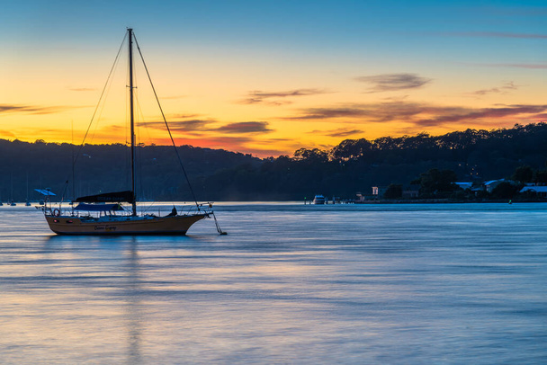 Ανατολή ηλίου και βάρκες από την Esplanade στο Ettalong Beach στην Κεντρική Ακτή, NSW, Αυστραλία. - Φωτογραφία, εικόνα