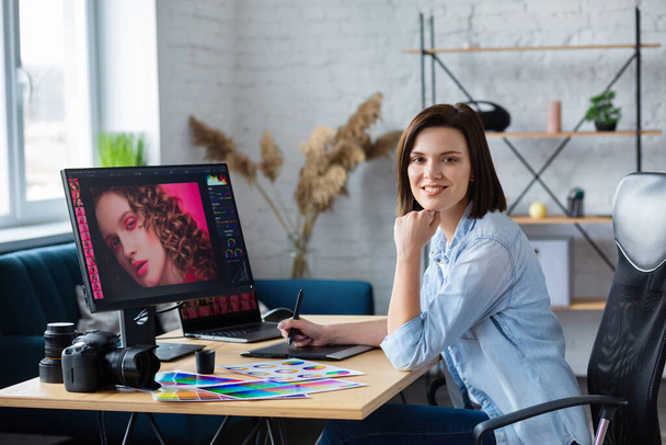 Portrait of graphic designer working in office with laptop,monitor,graphic drawing tablet and color palette.Retouching images in special program.Retoucher workplace in photo studio.Creative agency - Fotoğraf, Görsel