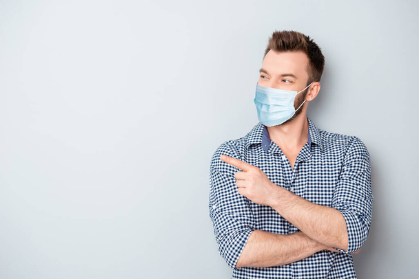 Portrait of his he attractive content guy wearing reusable gauze mask health care demonstrating copy space info poster placard isolated over grey light pastel color background - Фото, изображение