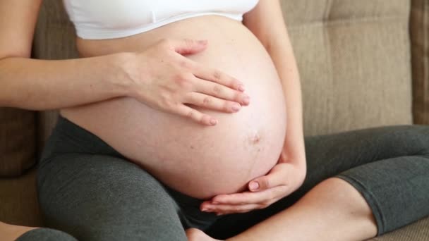Krásná těhotná žena hladí své břicho. matka doma dotýká se svého břicha - Záběry, video