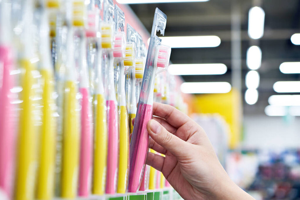 Toothbrush in a package in hand in the store - Photo, Image