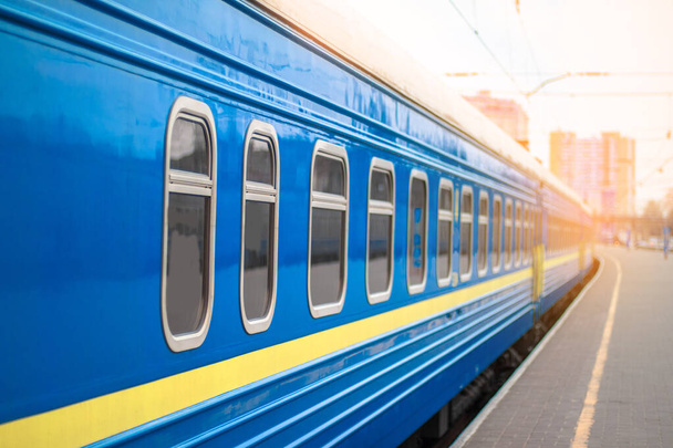 Блакитний потяг на станції в променях сонячного світла
 - Фото, зображення