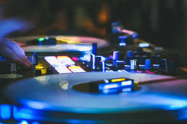 DJ-Plattenspieler im dunklen Nachtclub, Party im Tanzclub, DJ-Equipment, defokussiert  - Foto, Bild