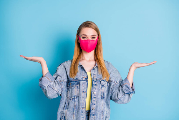 Photo of pretty lady social distancing not contact people hold open palms empty space showing two variants shopping sales discounts wear face mask denim blazer isolated blue color background - 写真・画像