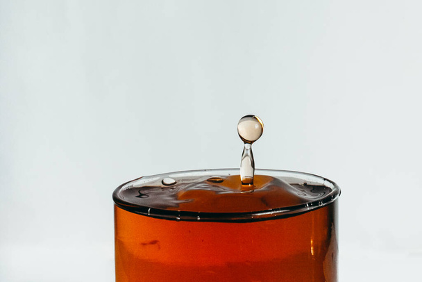 drop falling in glass with some drink  - 写真・画像