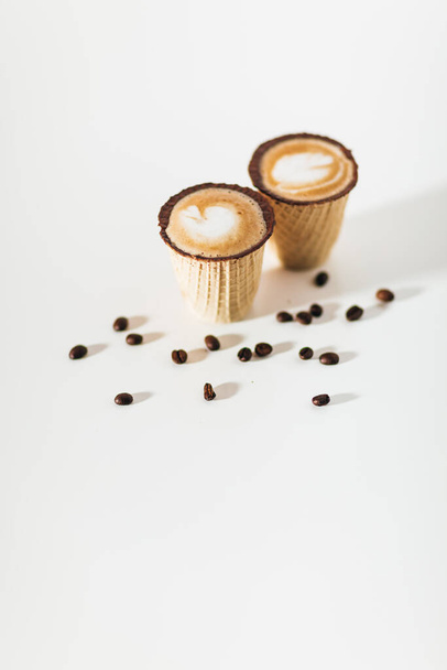 Kaffee in Waffeltassen auf weißem Hintergrund  - Foto, Bild