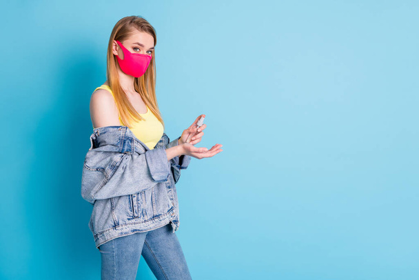 Profile photo of beautiful lady use purse organizer antiseptic spray disinfect arms after crowded social place wear face mask denim blazer yellow tank top isolated blue color background - Fotoğraf, Görsel