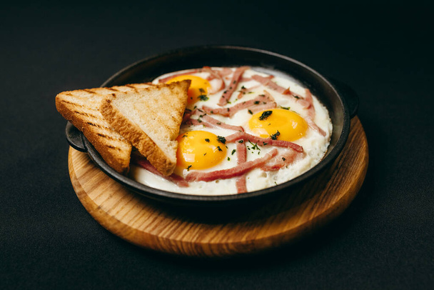 Pyszne smażone jajka z bekonem i dwoma tostami - Zdjęcie, obraz