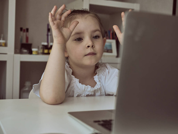 Мила дівчинка використовує ноутбук вдома. Освіта, онлайн навчання, домашнє навчанняКіди дистанційне навчання
 - Фото, зображення