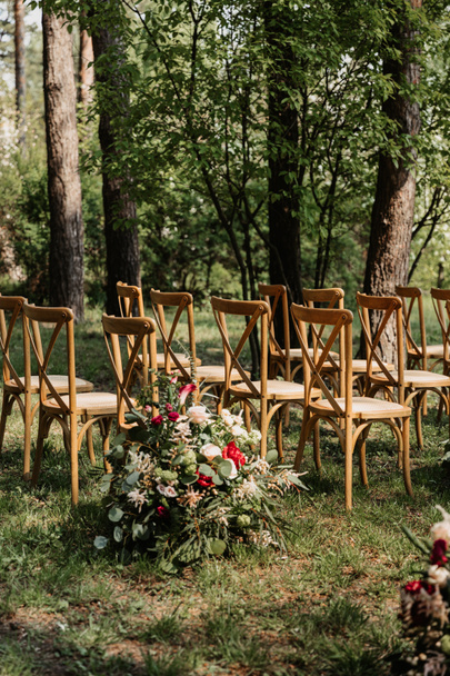 ξύλινες καρέκλες και διακόσμηση λουλουδιών, όμορφη εννοιολογική εικόνα κήπου γάμου - Φωτογραφία, εικόνα