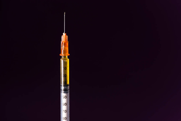 Strzykawka do szczepionki lub insuliny, z jej cieniem, na czarnym tle. Koncepcje dotyczące zdrowia, szczepień, wieńcowości lub leków - Zdjęcie, obraz