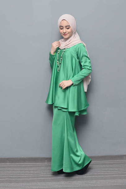 Hijab fashion.Nettes muslimisches Mädchen trägt Hijab und traditionelle Kleidung.Mode für eid Feier. - Foto, Bild