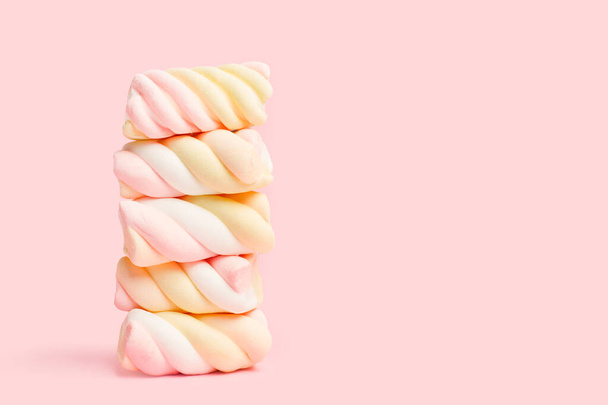 A heap of yellow and pink marshmallows on a pink background - Photo, Image