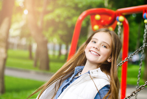 Happy smiling little girl child riding on a swing outdoor - Foto, Imagem