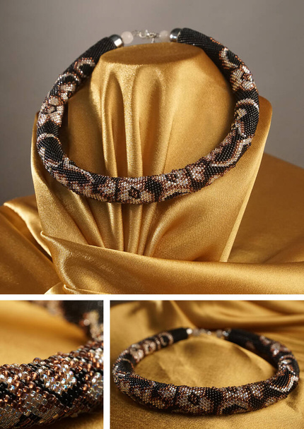 Korálkový provaz, perličky, náhrdelník. Černé korálky náhrdelník na zlatém saténu na šedém pozadí - Fotografie, Obrázek