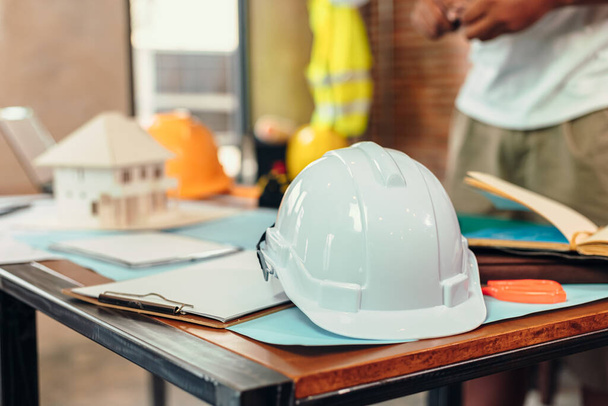 safety helmets  on the table at site construction. Architect, Engineer and businessman  read  planning background.  - Foto, Imagem