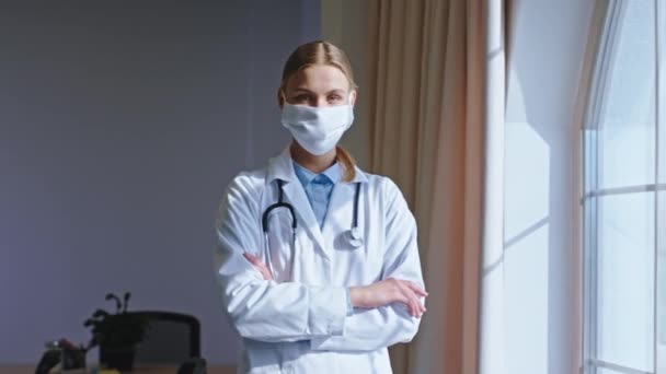 Beautiful young woman doctor with a protective mask she take a break looking through the panoramic window and thinking. Shot on ARRI Alexa Mini - Filmmaterial, Video