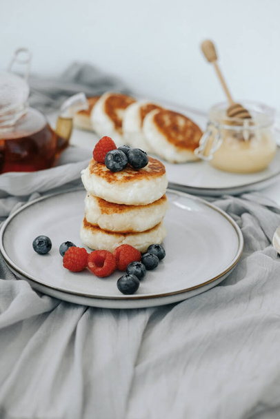 Tasty curd cheesecakes with berries on a plate - Photo, Image