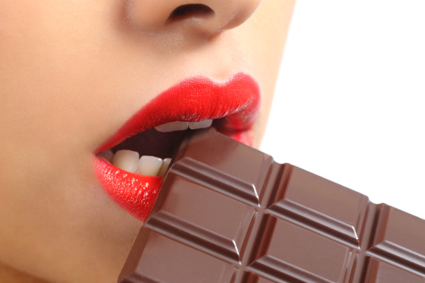 Beautiful woman red lips eating chocolate - Фото, изображение