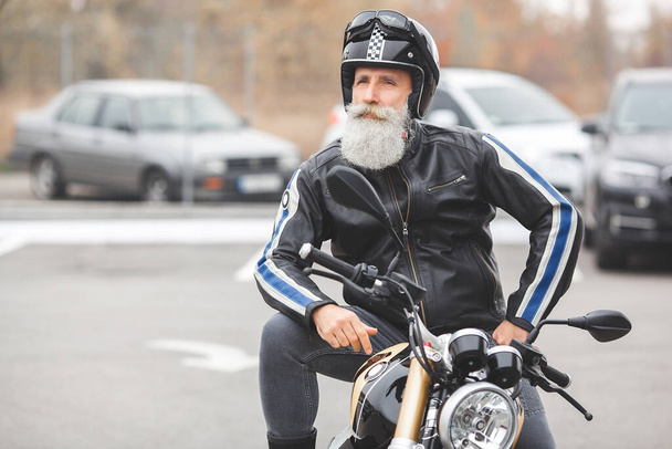 Vieil homme élégant conduisant la moto. Brutal masculin
. - Photo, image