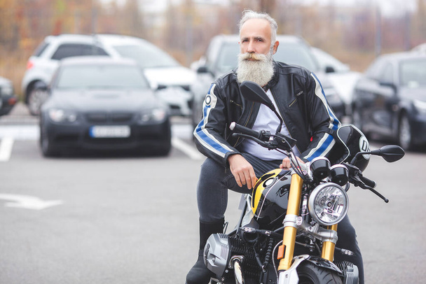 Alter, stilvoller Mann am Steuer des Motorrads. Brutaler Rüde. - Foto, Bild